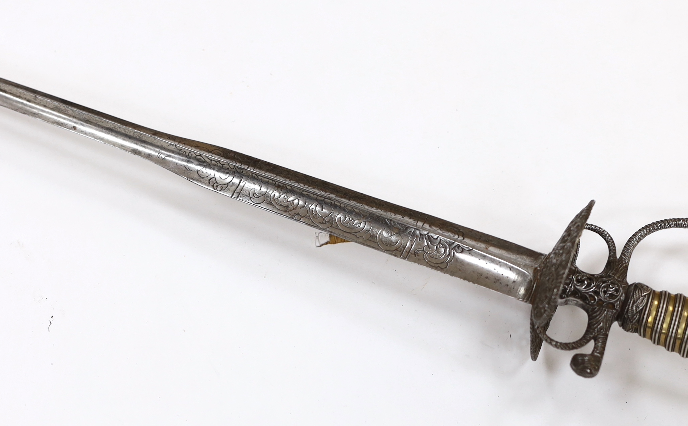 An English iron hilted small sword, c.1765, chiselled and pierced with scrolling devices and foliage, silver gilt tape and silver wire bound grip, colichemarde blade etched with scrolls and squirrel, blade 81.5cm